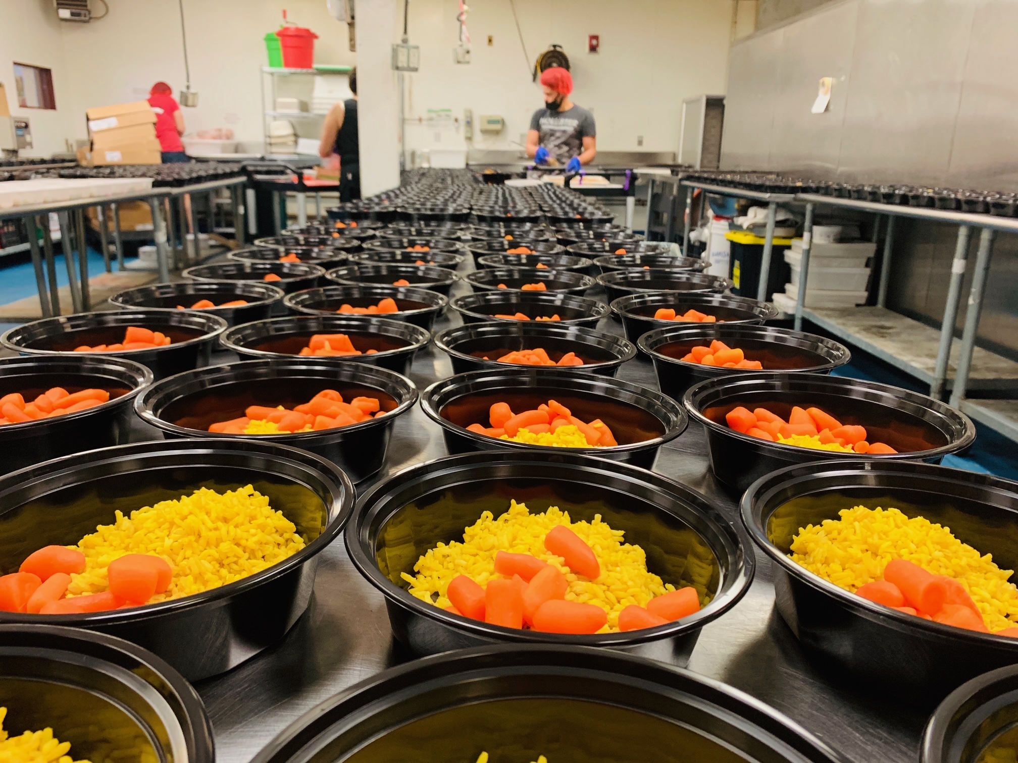 bowls lined up being prepared by man in Stock Pot Maldens shared kitchen